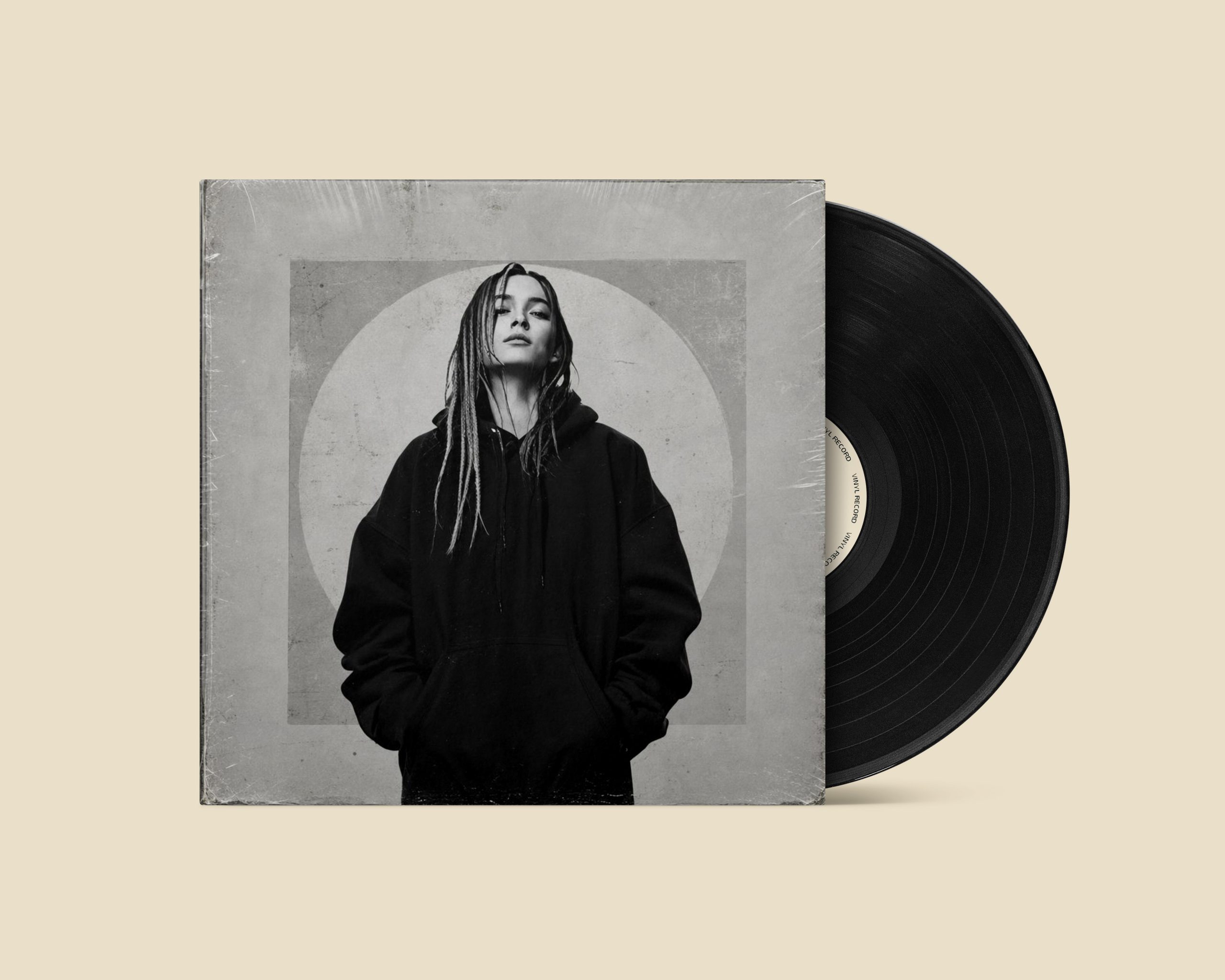 Black vinyl record beside a monochrome sleeve featuring an artist portrait